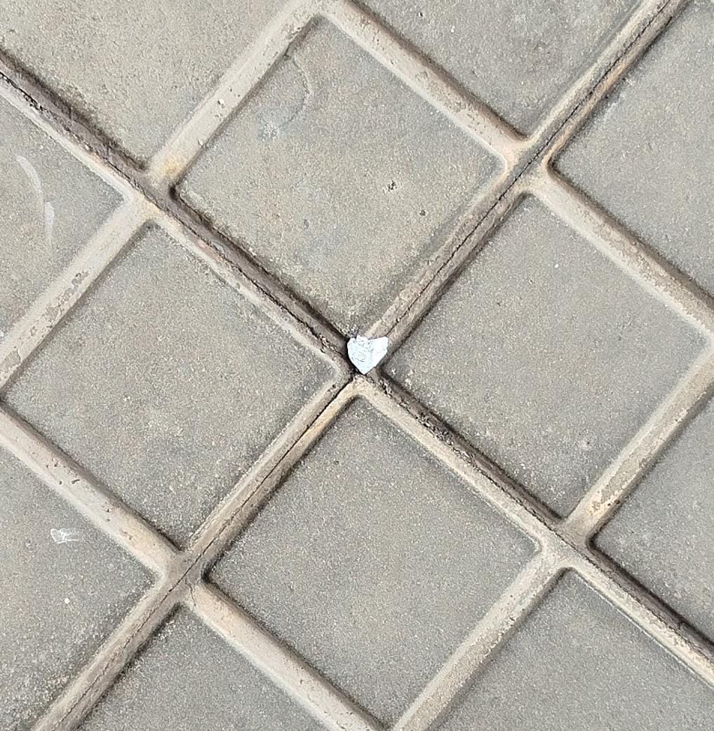 Corazón diminuto de papel en el suelo como símbolo de lo pequeño que puede recordarnos estar presentes